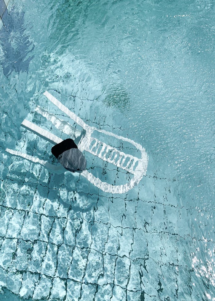 services-02 A captivating shot of a chair underwater in a swimming pool, displaying sunlit ripples.